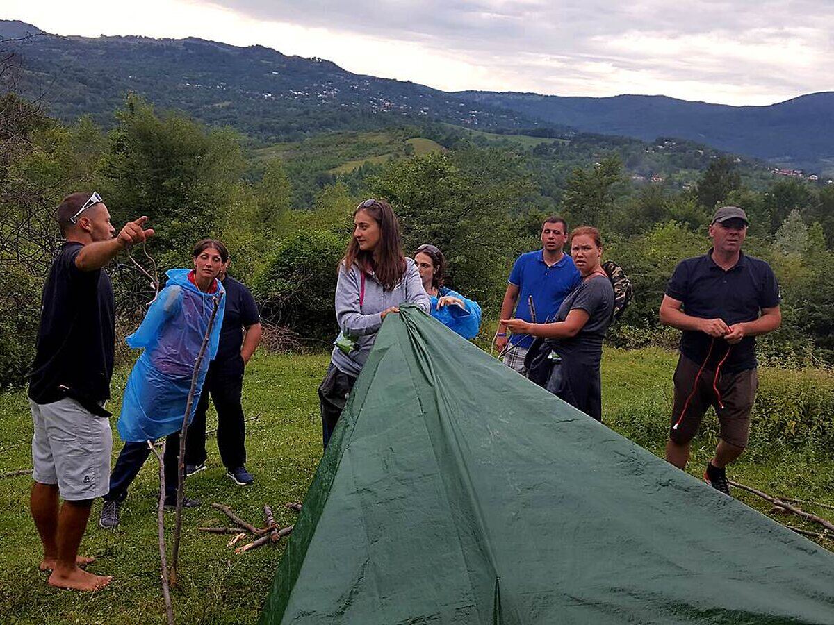 Participanți construind un adăpost în activitatea Survival