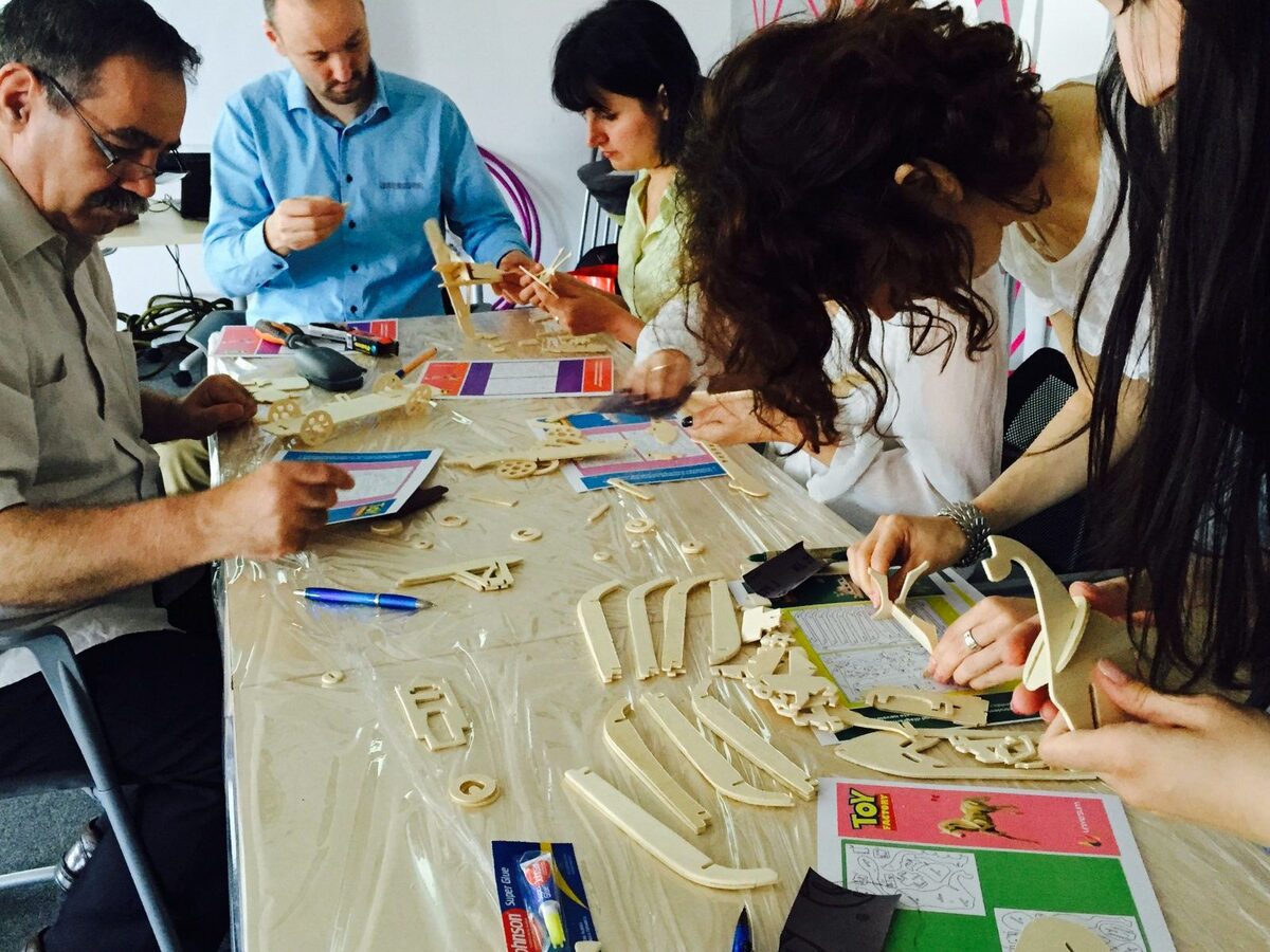 Participanți asamblând jucării în activitatea Toy Factory