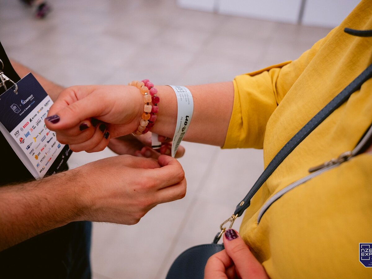 Event attendee receiving an access wristband at check-in.