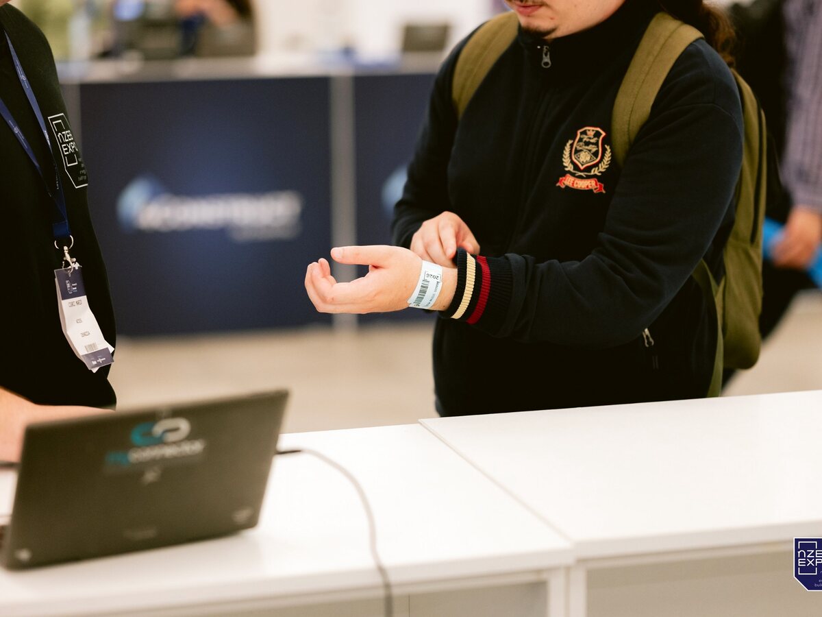 Attendee wristband being verified at an event registration desk.