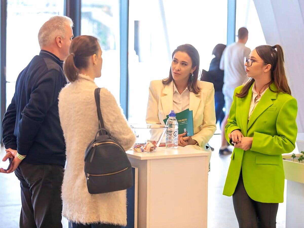 Vizitatori discutând cu un consultant imobiliar