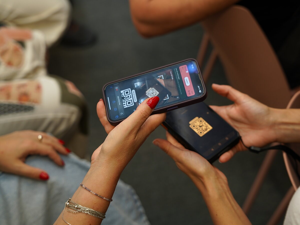 A close-up of a participant scanning another player’s LinkO QR code.