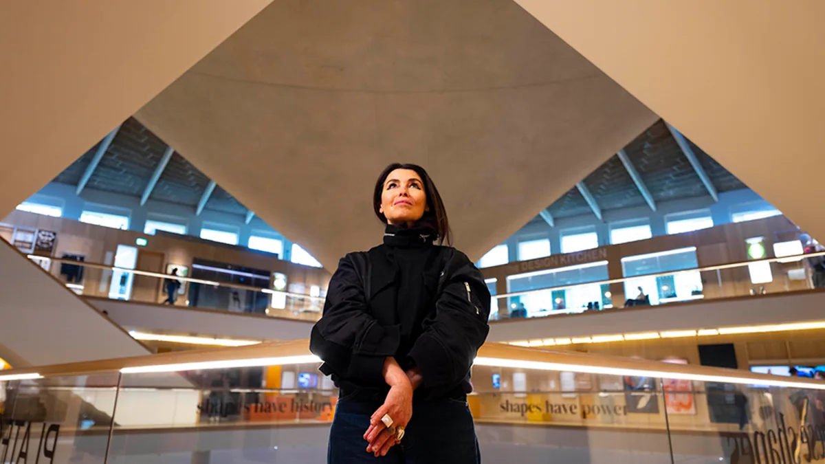 Es Devlin standing beneath a large suspended geometric installation